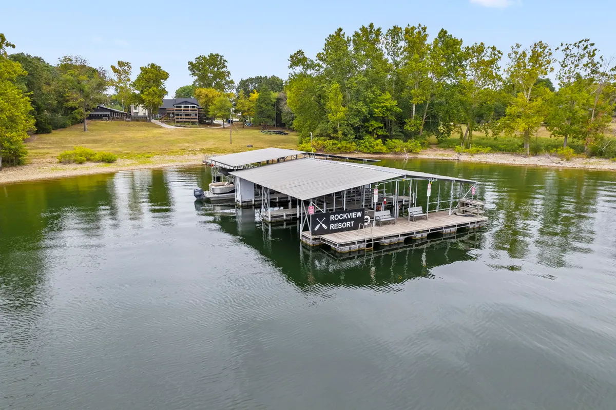 A tranquil lakeside dock with a boathouse and gentle water, surrounded by trees. The scene is inviting and suggests both relaxation and outdoor activities like boating and fishing—core activities described in the section.